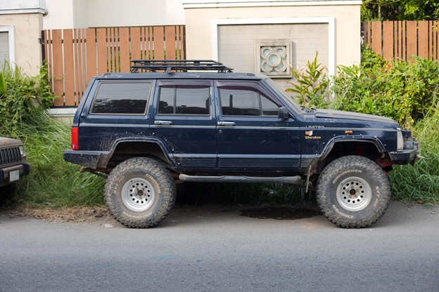 old blue Jeep Cherokee SUV parked on a road