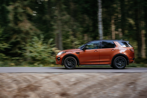 the Land Rover Discovery SUV driving along a country forest road