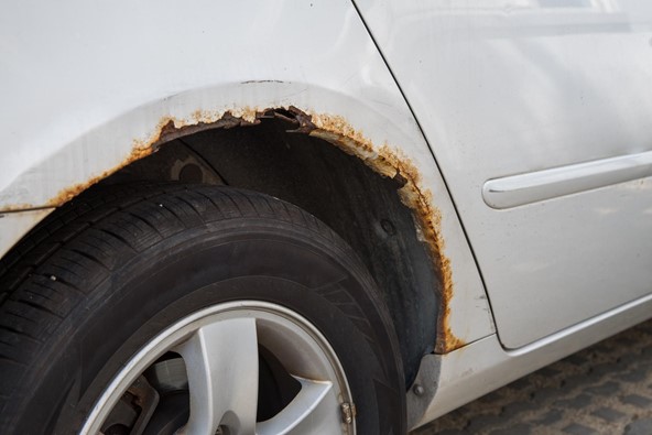 a car wheel arch that’s rusting and has sharp metal corners