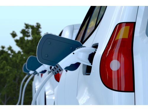 electric cars parked in a row charging at a power station